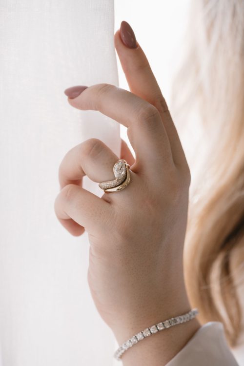 Aria engagement ring and coordinating wedding band in 14k yellow gold, shown worn together on hand—featuring an intertwined silhouette with a marquise-cut center stone and pavé accents that flow seamlessly in sculptural harmony.