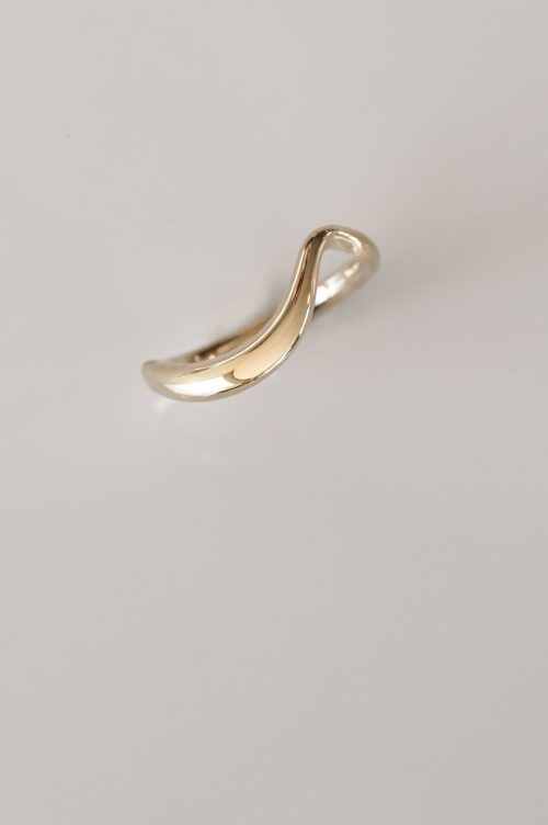 14k yellow gold Aria wedding band with curved, tapered shape.