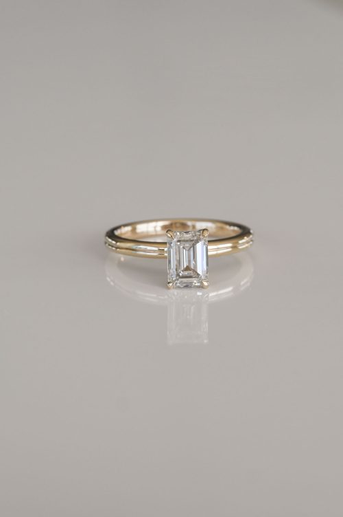 Chloe engagement ring in 14k yellow gold with 14k ultra white gold setting, front view featuring an emerald-cut diamond with a hidden halo detail.