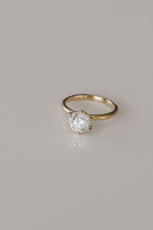 Laleh engagement ring in 14k yellow gold, angled view showcasing the round brilliant diamond in a tulip-shaped floral setting.