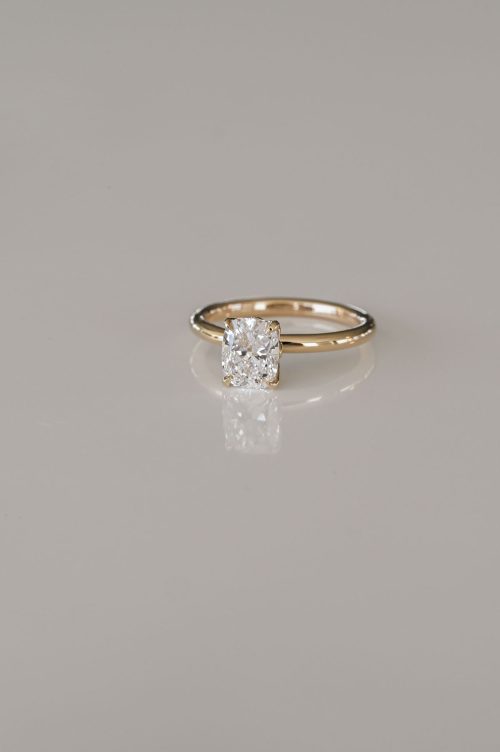 Hana engagement ring in 14k yellow gold, front view featuring a cushion-cut diamond held in a sculptural tulip-style setting with petal-like prongs.