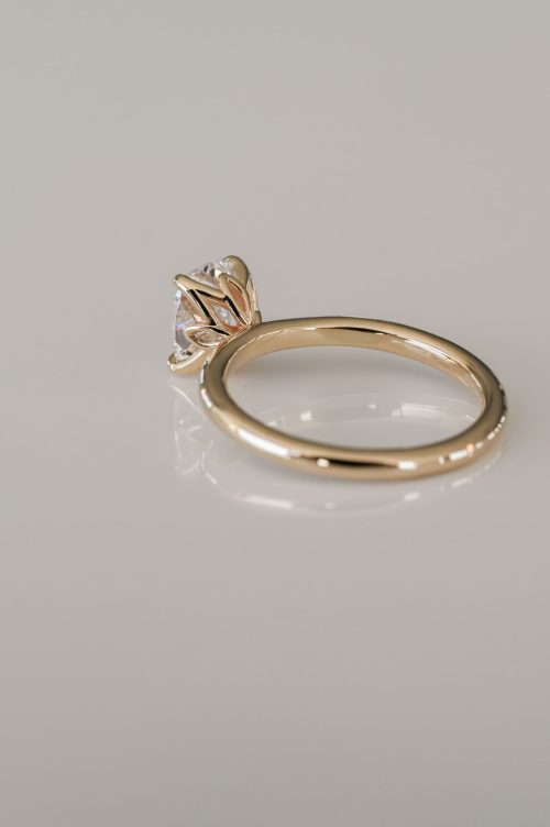 Hana engagement ring in 14k yellow gold, rear view showing the cushion-cut diamond embraced by a sculptural tulip-style setting with petal-like prongs.