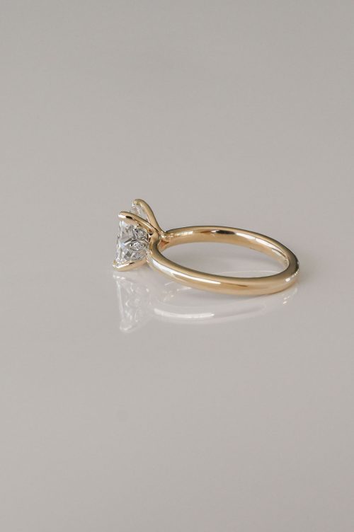 Flora engagement ring in 14k yellow gold with 19k white gold setting, side view featuring an elongated cushion-cut diamond and delicate petal-inspired details.