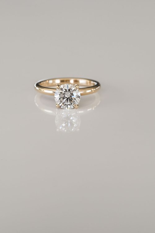 Laurel engagement ring in 14k yellow gold, front view featuring a round brilliant diamond with petal-shaped pavé prongs in a floral-inspired setting.