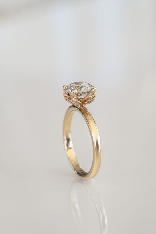 Laurel engagement ring in 14k yellow gold, featuring a round brilliant diamond held by petal-shaped pavé prongs in a flower-inspired setting.