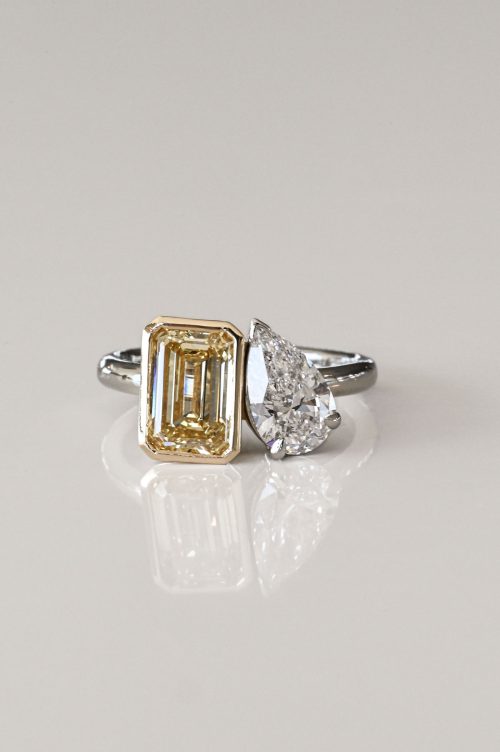 Ava toi et moi ring in white and yellow gold, featuring a fancy yellow emerald-cut diamond paired with a white pear-cut diamond.