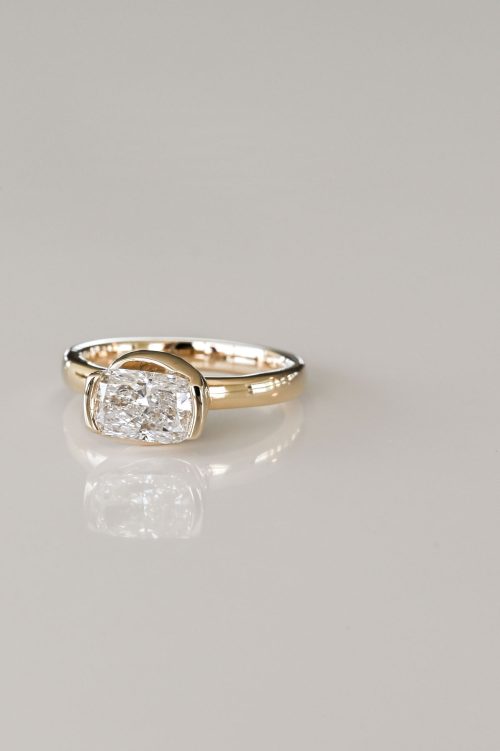 Eloise engagement ring in 14k yellow gold, front view showcasing a cushion-cut diamond in a bold bezel setting with sculptural knot-inspired design.