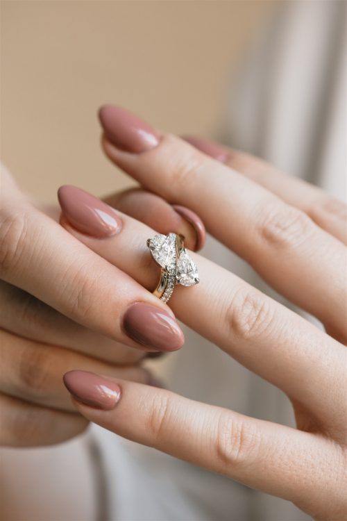 Close-up of the Alana wedding band on the hand, showing a curved yellow gold band with pavé-set diamonds, designed to nest perfectly alongside the Alana engagement ring.