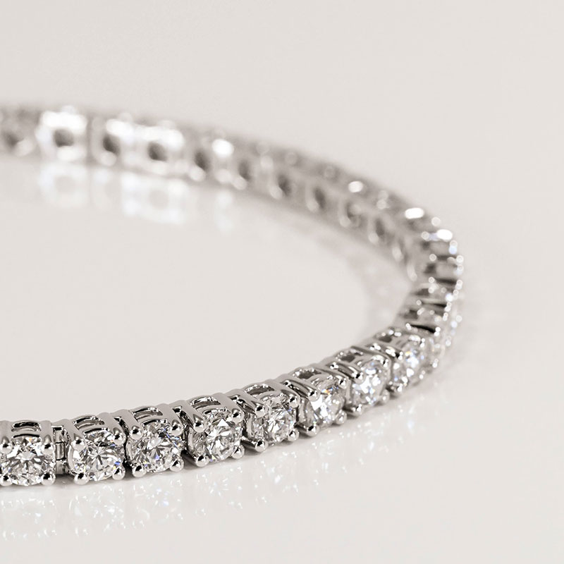 Classic diamond tennis bracelet in white gold, featuring a continuous row of round brilliant-cut diamonds in four-prong settings.