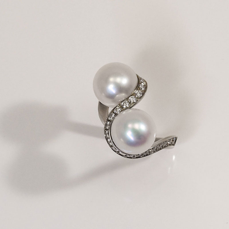 GemstoneRings-2 White gold bypass ring featuring two round white pearls accented by a curved row of pavé-set diamonds.
