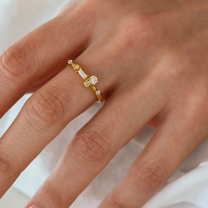 AnniversaryRings-4 Yellow gold ring with a mix of white and yellow diamonds in various cuts on a woman's finger.