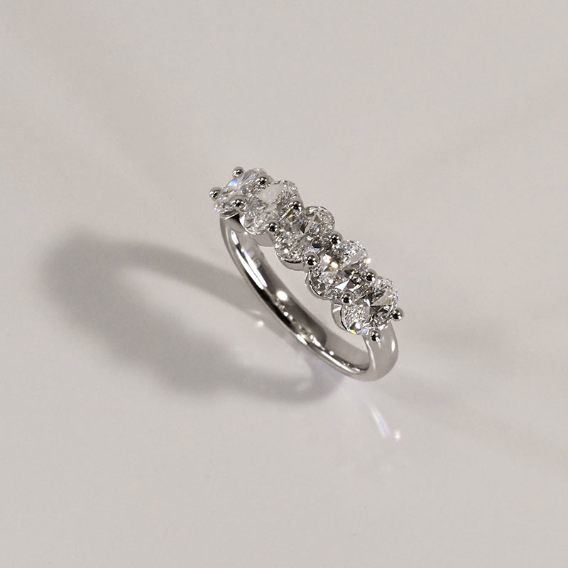 AnniversaryRings-5 White gold ring with a row of oval-cut diamonds set across the top.