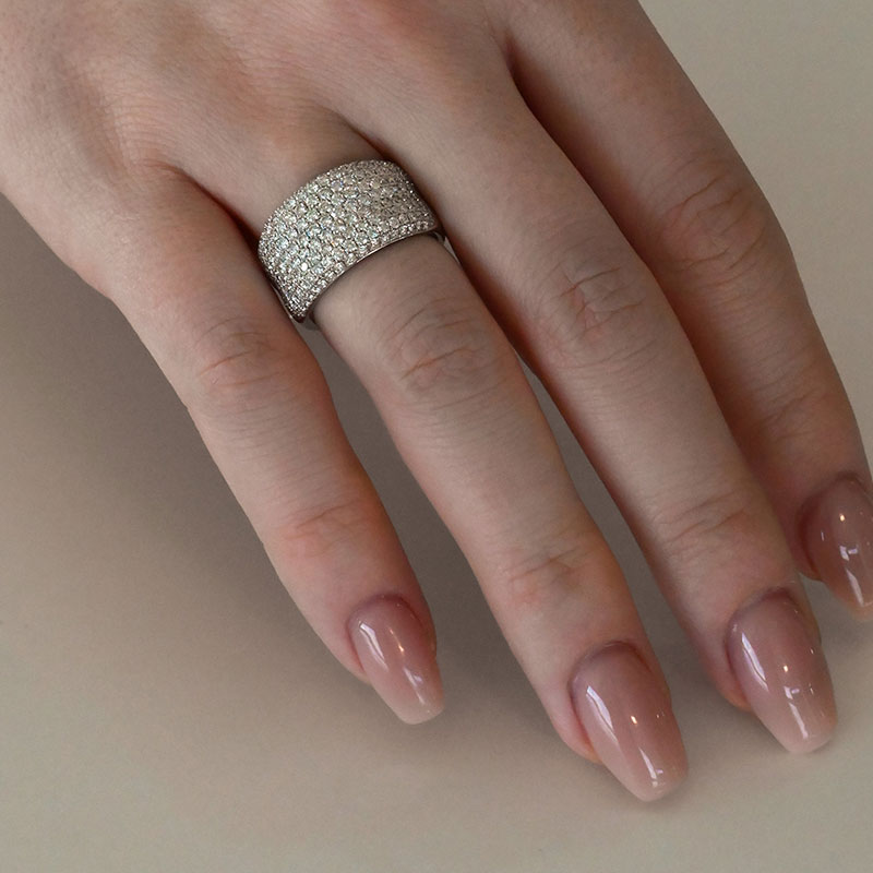 AnniversaryRings-6 Wide band white gold ring featuring multiple rows of small round diamonds on a woman's finger.